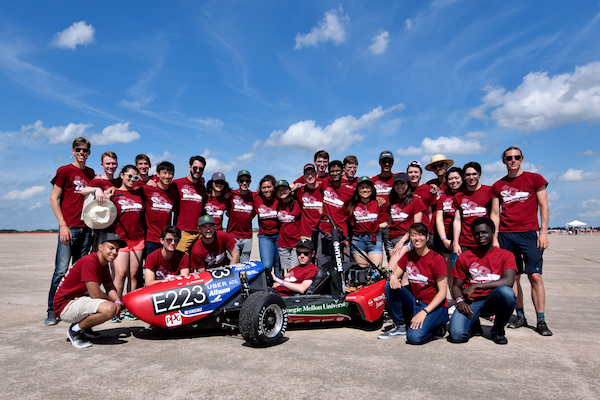 CMU racing students in front of car