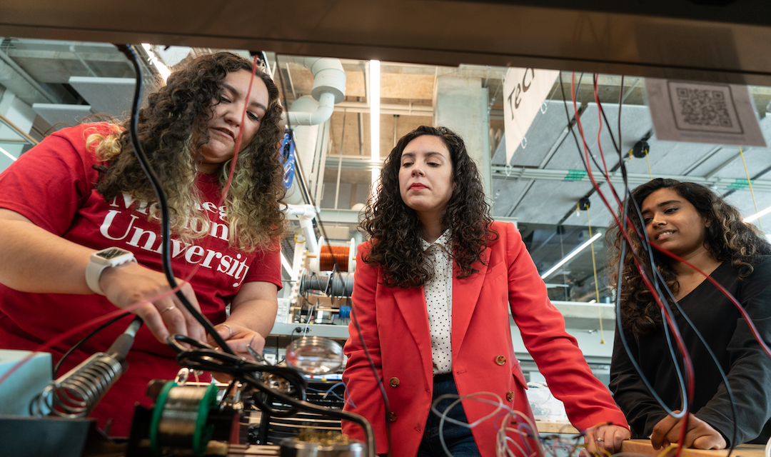 women in engineering standing at table