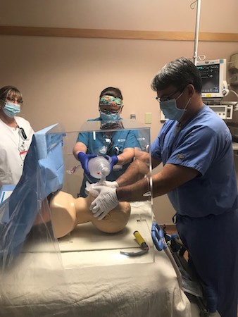 A medical teams tries the containment box with a manikin.