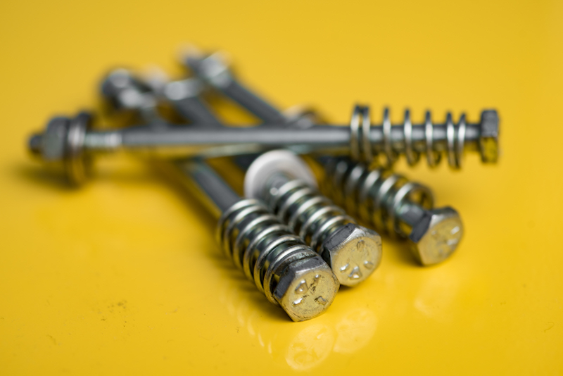 metal screws on a yellow background
