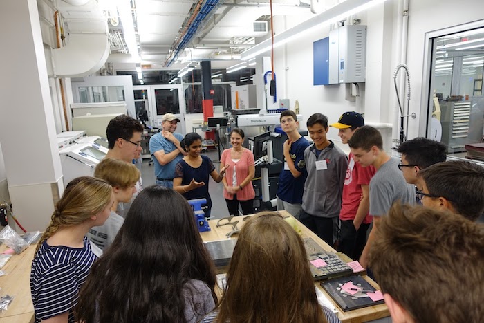 Photo of Sneha Prabha Narra and students in an additive manufacturing lab.