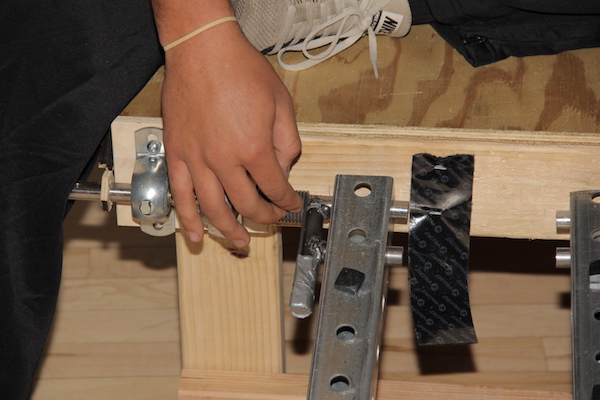 A mechanical engineering students adjusts an assistive hamstring stretch device. 